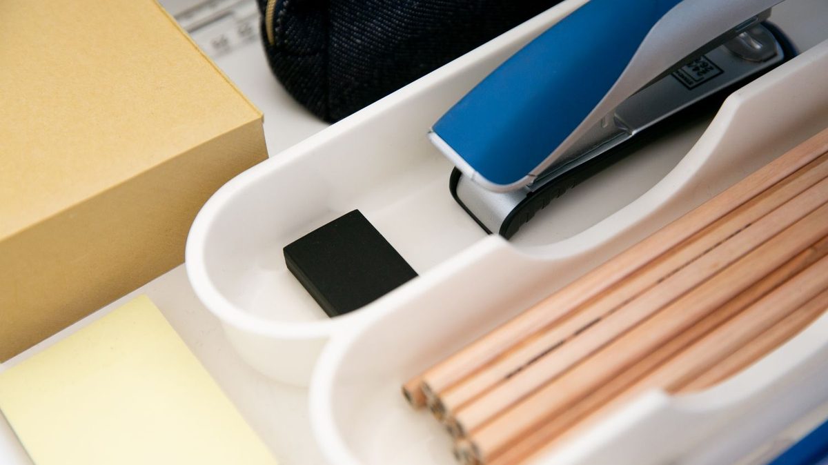 Office stationery items laid out on a desk tray